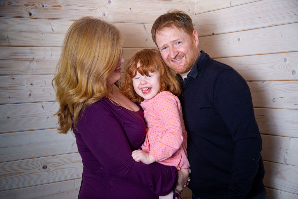 A family photo of the Lovely Things family, Laura, Ciaran and their youngest child. Everyone is smiling and laughing together. 
